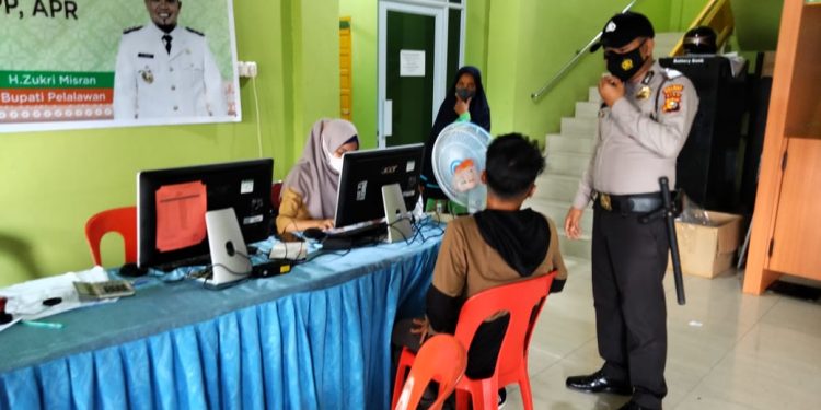 Personil Polsek Kuala Kampar Dampingi Nakes Dalam Kegiatan Vaksinasi di Puskesmas