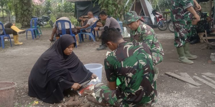 Satgas TNI Bantu Ibu Ariama Mengupas Ubi di Lokasi TMMD ke 114
